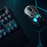 Futuristic gaming mouse and mechanical keyboard with blue LED lighting on hexagonal backdrop.