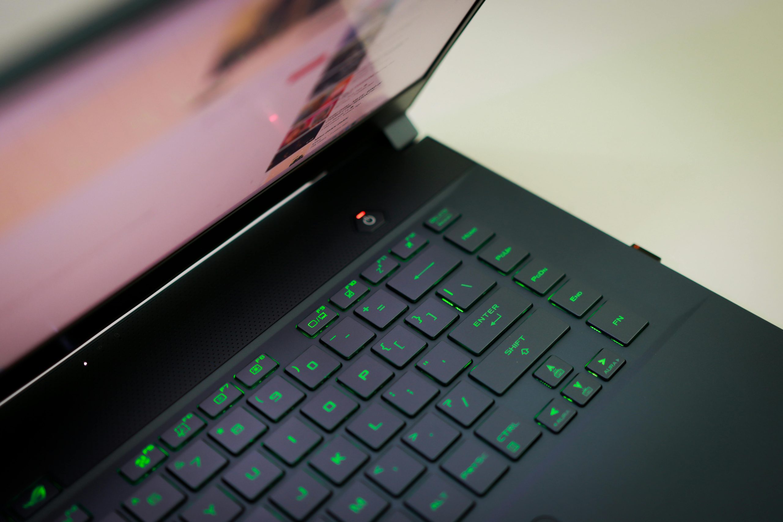 A sleek laptop with a glowing green keyboard illuminated, showcasing modern technology.